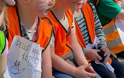 Ansiktsmålade barn med skylten Pelle och Majaloppet
